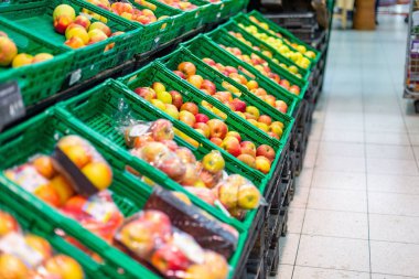 Süpermarkette yeşil plastik kutu içinde kırmızı ve yeşil taze elma