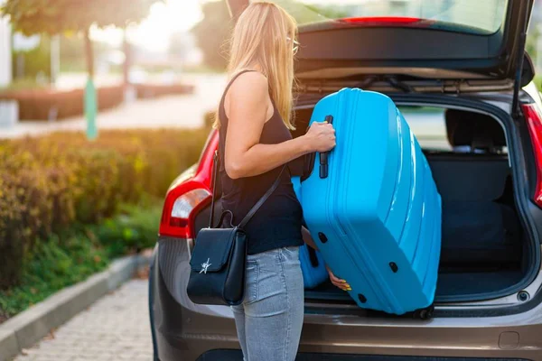 Mujer Joven Cargando Dos Maletas Plástico Azul Maletero Del Coche — Foto de Stock