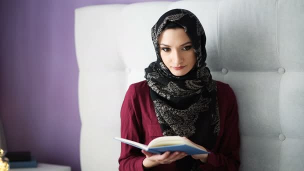 阿拉伯妇女在头巾阅读一本书在卧室里 — 图库视频影像