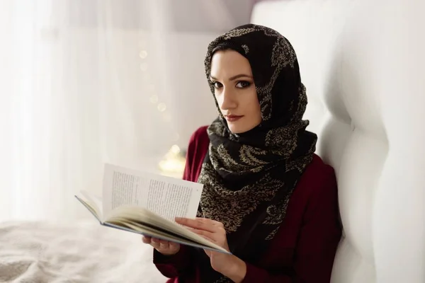 阿拉伯妇女在头巾阅读一本书在卧室里 — 图库照片