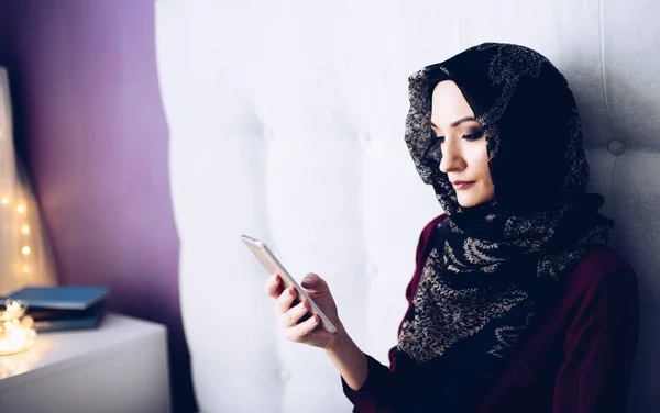 在卧室里使用智能手机的中东族裔妇女 — 图库照片