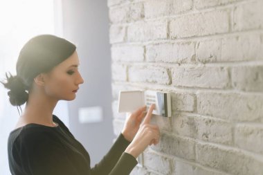 Kadın girerken güvenlik ev alarmı tuş takımında pin. Ev güvenlik sistemi