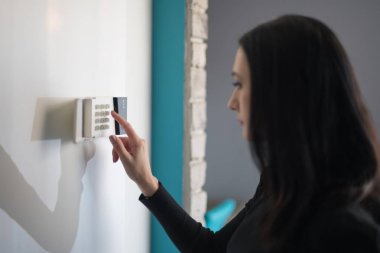 Kadın girerken güvenlik ev alarmı tuş takımında pin. Ev güvenlik sistemi