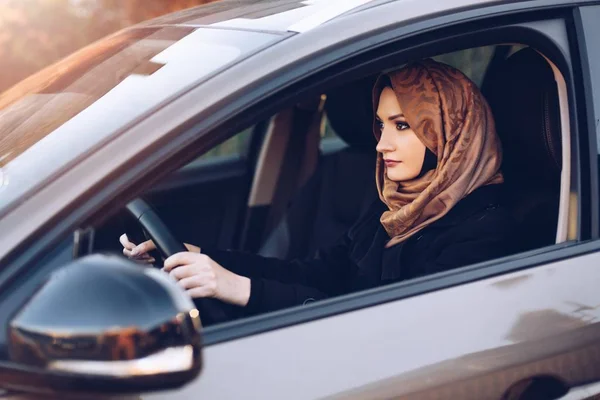 年轻的阿拉伯妇女在头巾驾驶汽车 — 图库照片