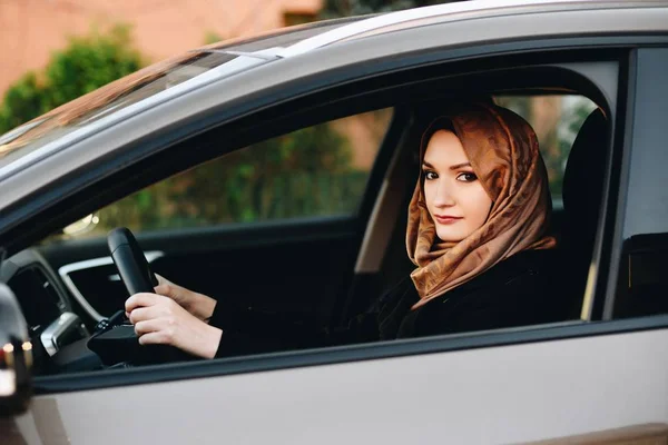 Muslim woman in car as driver. Arabic woman in hijab driving a car