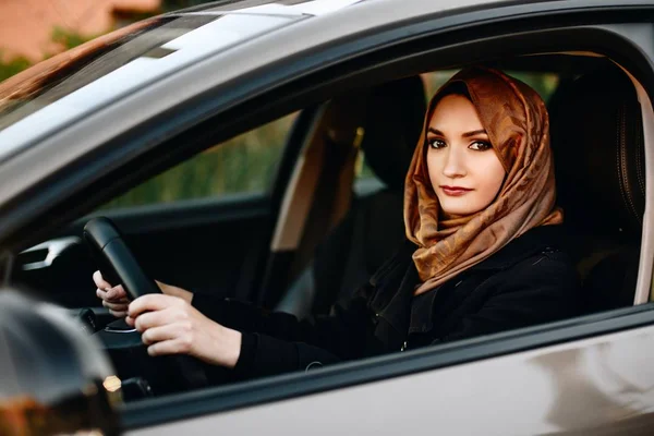 Muslim woman in car as driver. Arabic woman in hijab driving a car