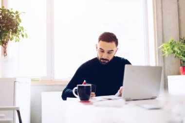 Ofiste dizüstü bilgisayar üzerinde çalışan beyaz delikanlı