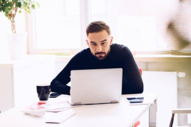 Ofiste dizüstü bilgisayar üzerinde çalışan beyaz iş adamı