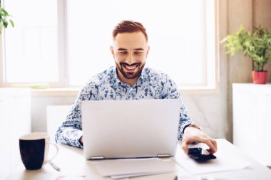 Caucasian happy smiling businessman working on laptop in his office. Man working in office