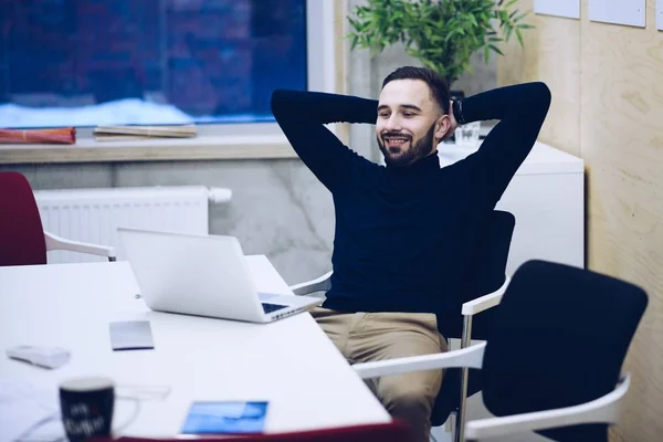 Businessman satisfied with work done. Man working on laptop while sitting at his working place in office. Man working in office