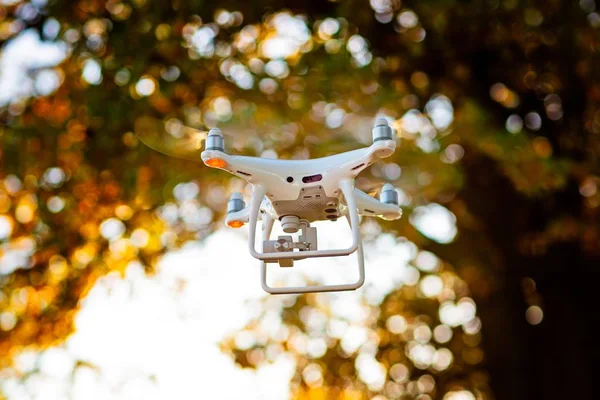 Professional drone with camera in flight. White drone quadrocopter. Unmanned aerial vehicle