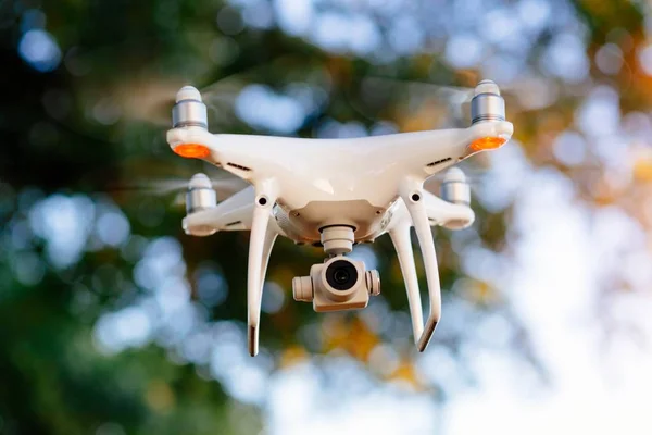 Unmanned aerial vehicle. White drone quadrocopter in flight