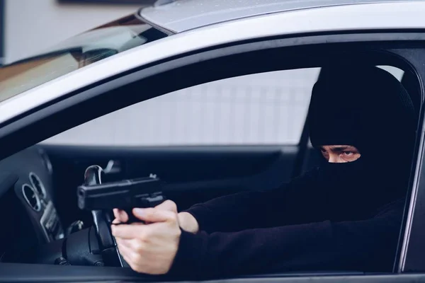 車でピストル銃を持つ仮面のテロリスト — ストック写真