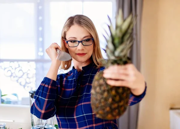 Woman opening pineapple with knife in kitchen — Stock Photo, Image