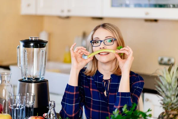 Woman with celery in the kitchen — Stock Photo, Image