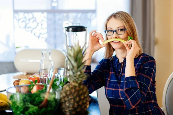Woman with celery in the kitchen — Stock Photo, Image