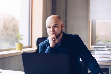 Düşünceli adam ofis dizüstü bilgisayar üzerinde çalışan