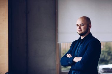 Ofiste cam kenarında duran genç işadamı.