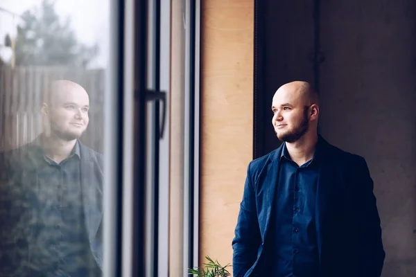 Jungunternehmer steht im Büro am Fenster. — Stockfoto