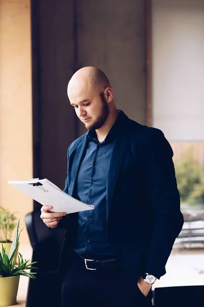 Joven hombre de negocios leyendo documentos en la oficina —  Fotos de Stock