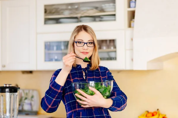 Woman preparing kale salad in a glass bowl — Stock Photo, Image