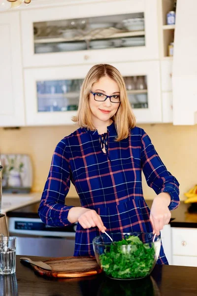 Woman preparing kale salad in a glass bowl — Stock Photo, Image