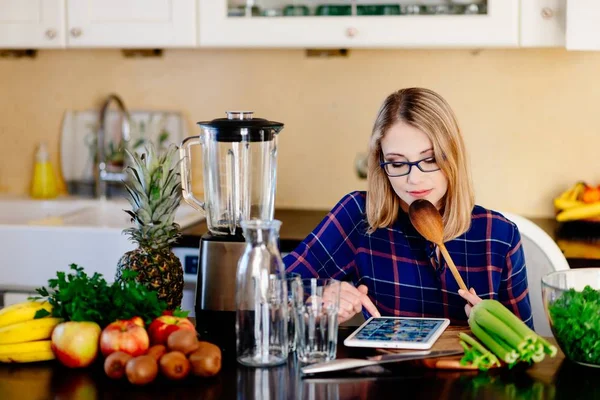 Young happy pregnant woman searching in internet for recipe for smoothie — Stock Photo, Image