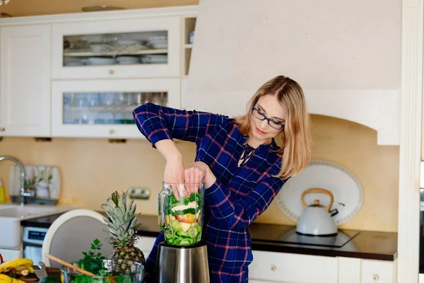 Young happy woman preparing smoothie cocktail in blender — Stock Photo, Image