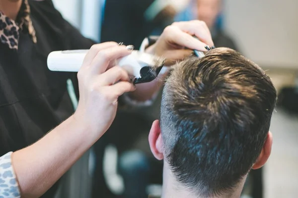 Cabeleireiro cortando o cabelo do homem com aparador elétrico — Fotografia de Stock