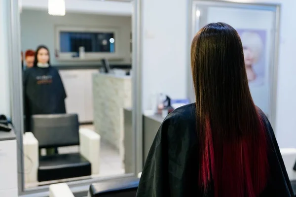 Mulher olhando para seu novo corte de cabelo no espelho . — Fotografia de Stock