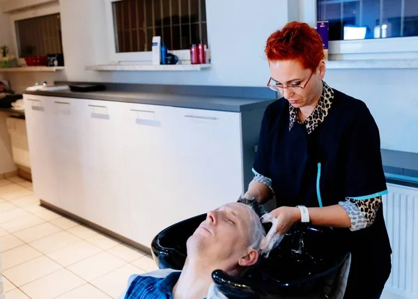Перукарське миття чоловічого волосся клієнта в салоні — стокове фото