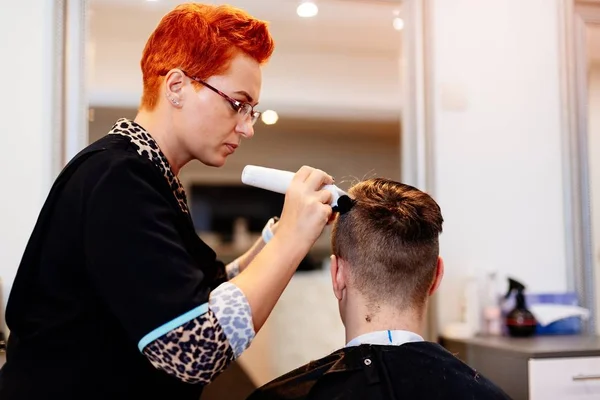 Cabeleireiro cortando o cabelo do homem com aparador elétrico — Fotografia de Stock