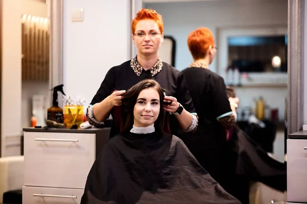 Mulher cabeleireiro mostrando novo corte de cabelo para seu cliente — Fotografia de Stock