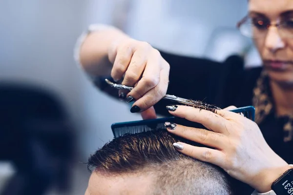 Vrouw Kapper snijden man's haren met een schaar. — Stockfoto