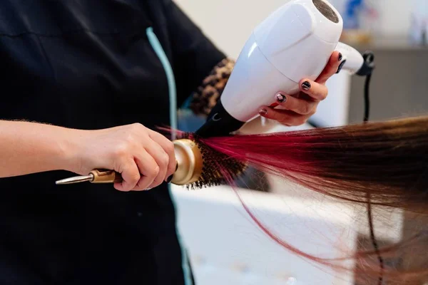 Cabeleireiro secagem mulher cabelo com secador de cabelo . — Fotografia de Stock