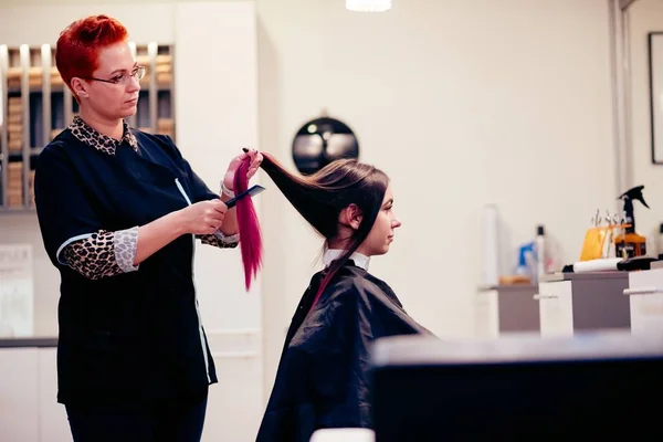 Перукар розчісує жінку клієнтське волосся — стокове фото