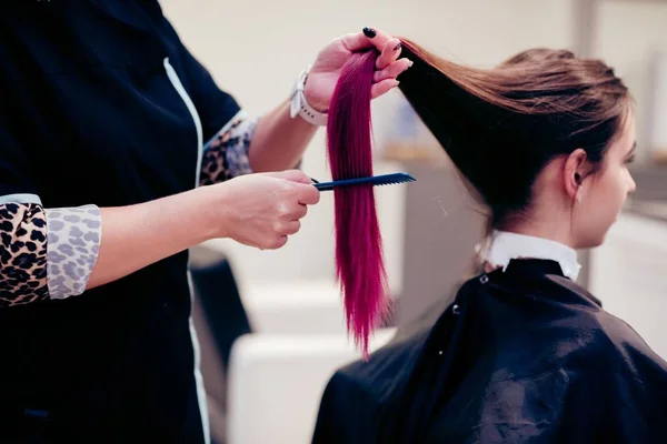 Перукар розчісує жінку клієнтське волосся — стокове фото