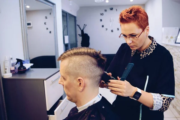 Vrouw Kapper snijden mannelijke klant haar met elektrische trimmer. — Stockfoto