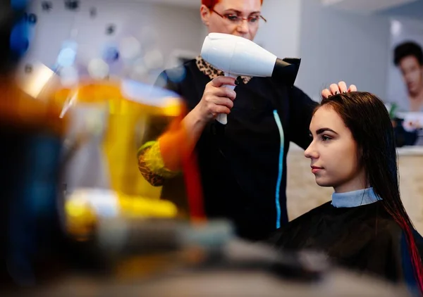 Cabeleireiro secagem de cabelo do cliente com secador de cabelo . — Fotografia de Stock