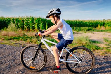 Küçük çocuk çocuk onun bisiklet sürme beyaz kask içinde