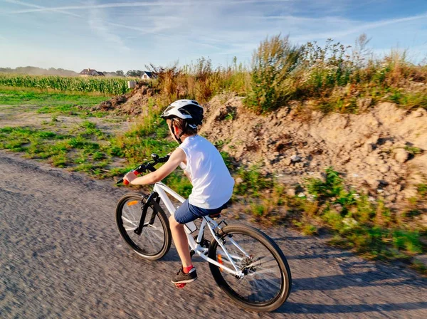 Маленький хлопчик в білому шоломі їде на велосипеді — стокове фото