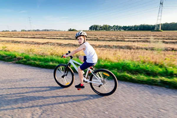 Маленький хлопчик в білому шоломі їде на велосипеді — стокове фото