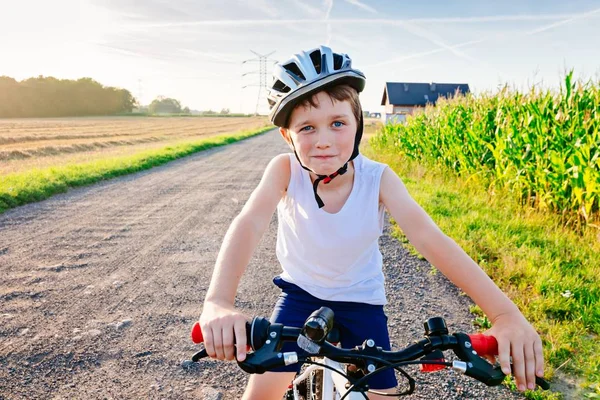 Happy little child boy in white helmet on bicycle — Stock Photo, Image