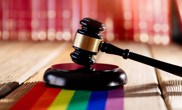 Judge wooden mallet - symbol of law and justice with lgbt rainbow colours flag