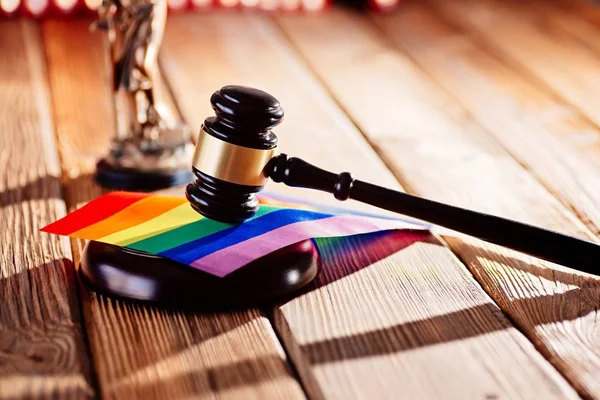 Judge wooden mallet - symbol of law and justice with lgbt rainbow colours flag