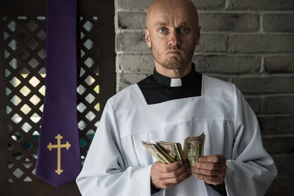 Sacerdote católico contando dinheiro na mão — Fotografia de Stock