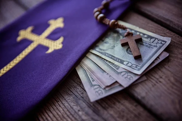 Wooden rosary and catholic church symbols and money