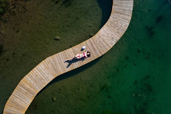Aereo drone vista donna in costume da bagno prendere il sole sul molo — Foto Stock
