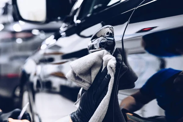 Arbeiter in Waschanlage poliert Auto mit Tuch — Stockfoto