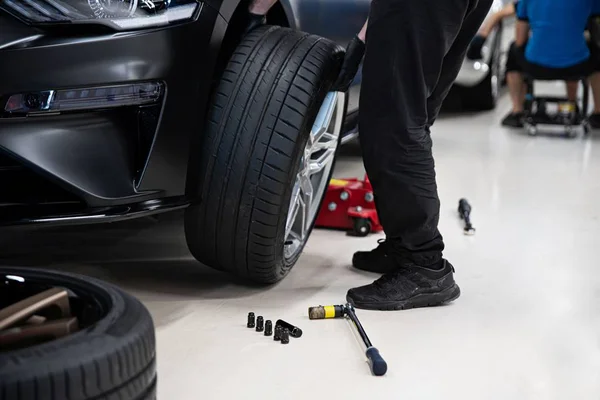 Roda de mudança mecânica e pneu. Serviço de carro — Fotografia de Stock